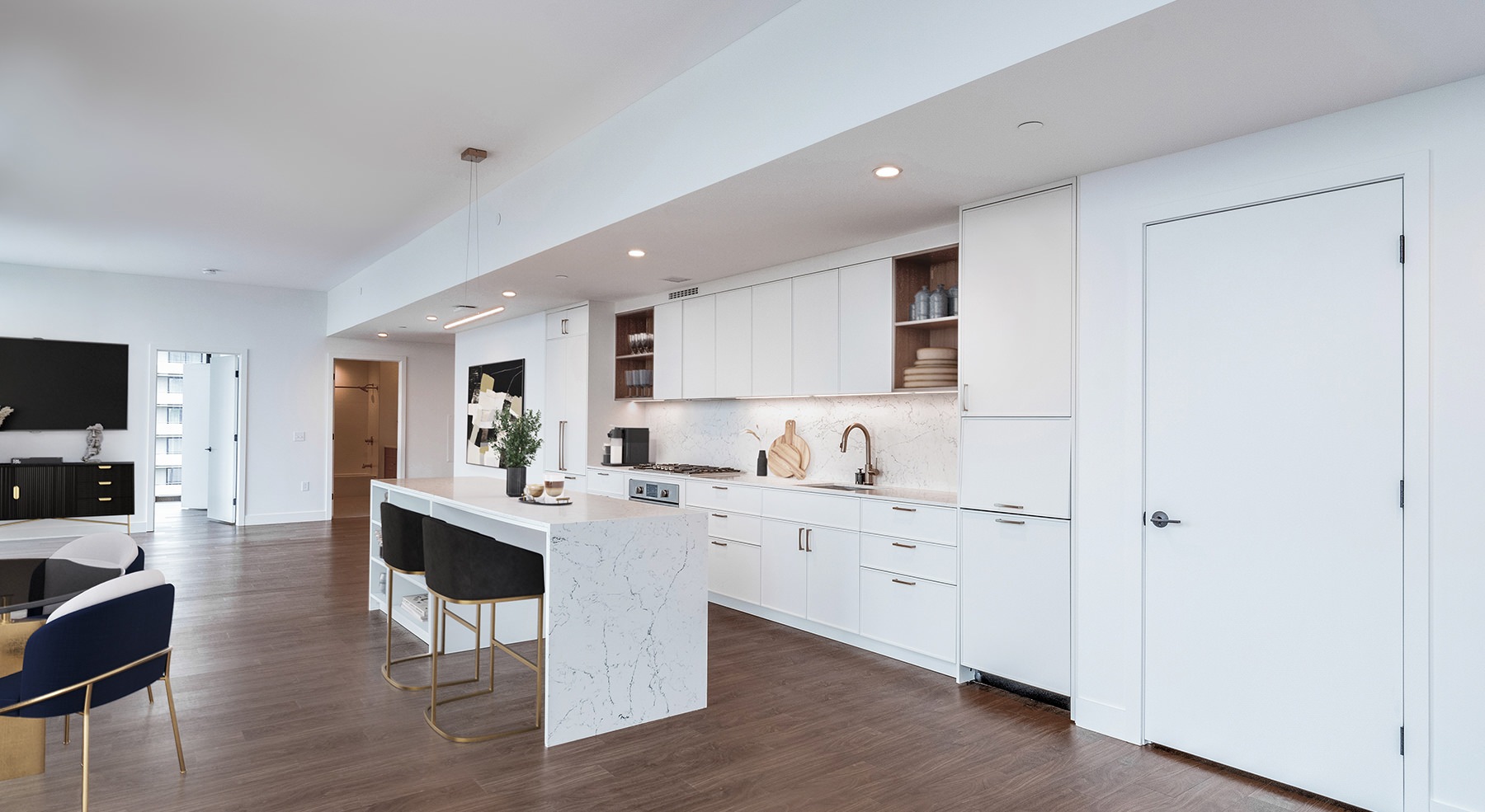 Spacious and well lit kitchen with wood floors and stainless steel appliances